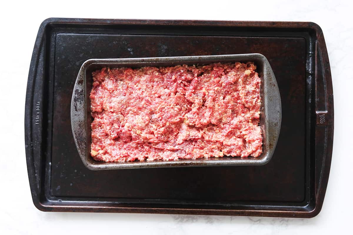 Ground beef mixture in a loaf pan.