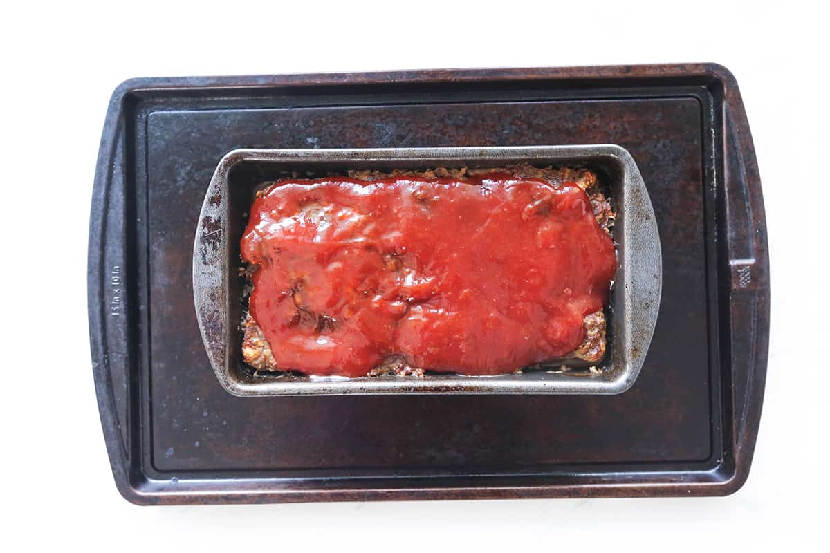 Sauce spread over top of dinner in a pan.