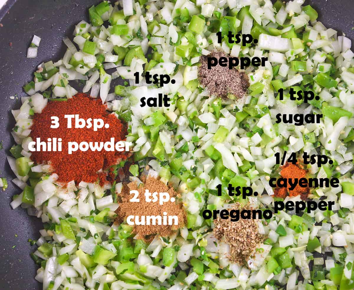 Spices on top of peppers and onions in skillet.