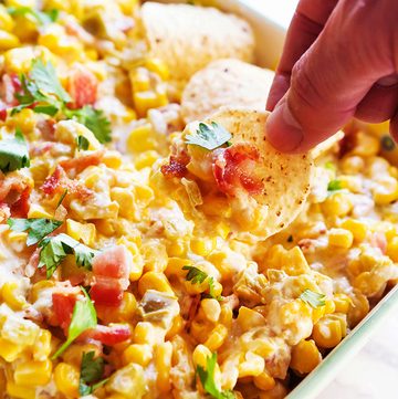 Cream cheese corn dip with herbs and tortilla chips for snacking.